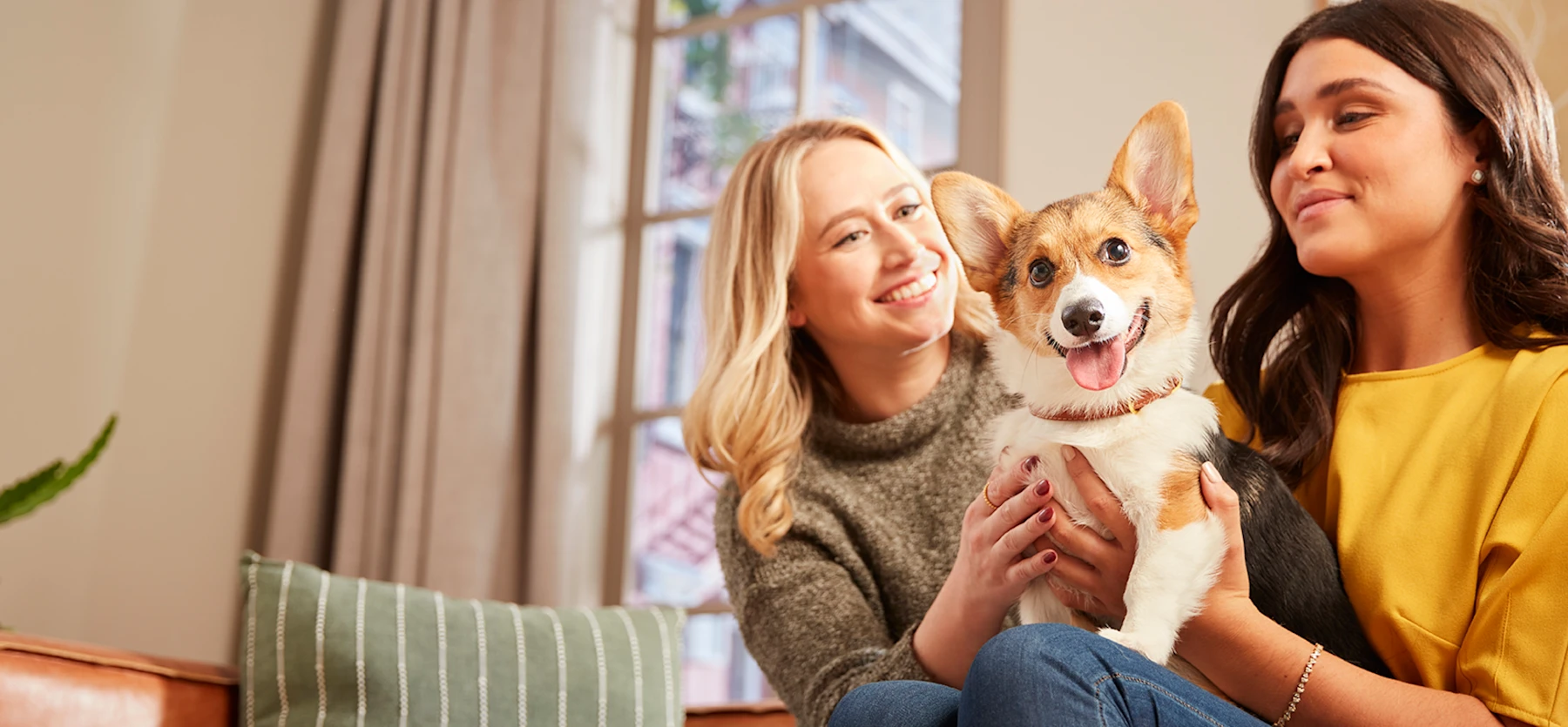 Two pet owners with a corgi, photographed for Embrace Pet Insurance